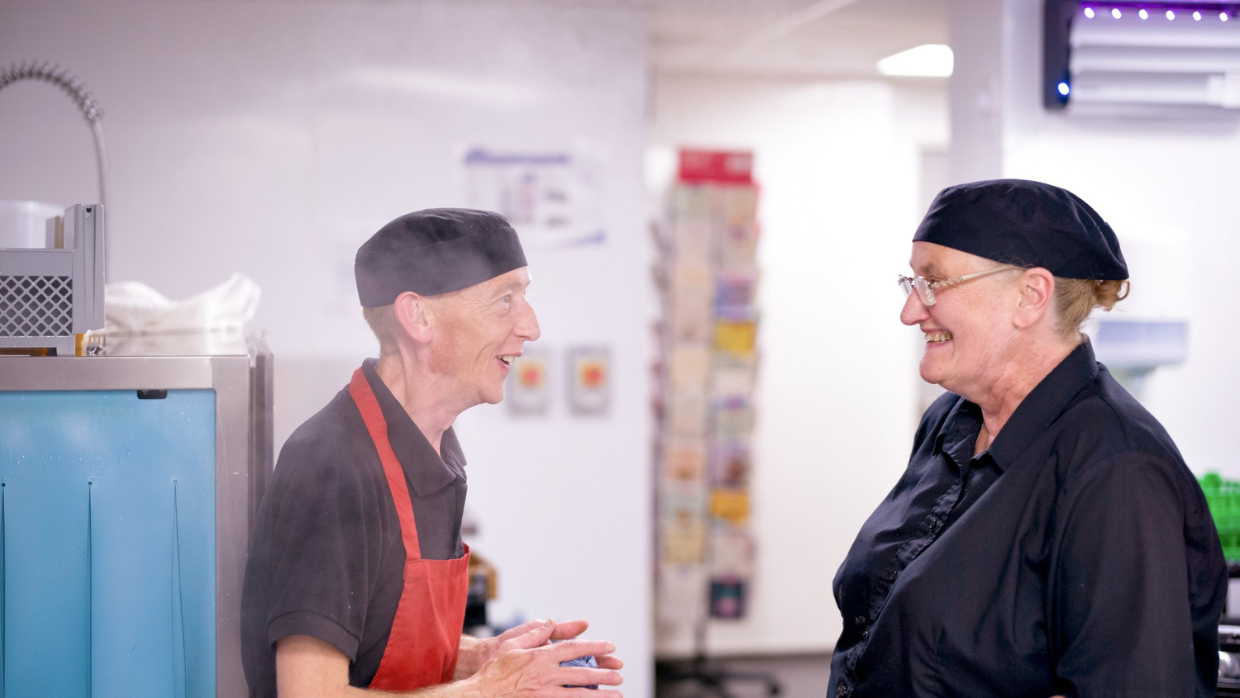 Two colleagues discussing and smiling.
