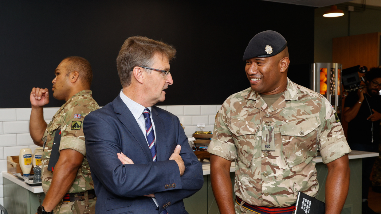 A military officer engaging in conversation with a group of individuals.