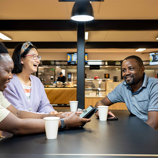 A diversed group of people sitting at a table happily chatting