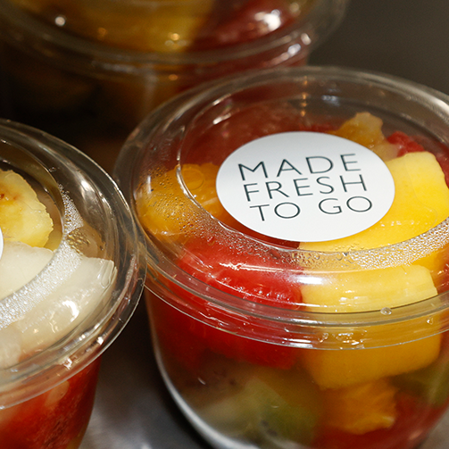 A variety of fruits neatly arranged in recyclable plastic containers