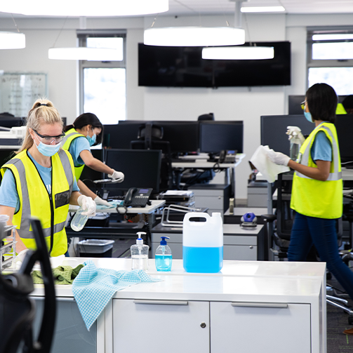 A group of people wearing safety vests and gloves in an office