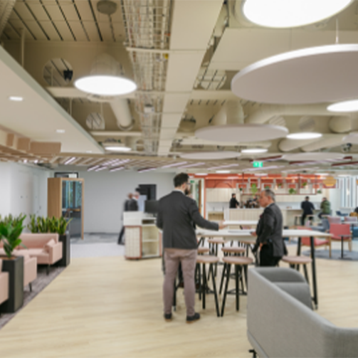 People standing in an open office area, working and collaborating in a modern and spacious environment