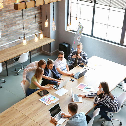 Top down view on a group of people sitting around a desk working and discussing
