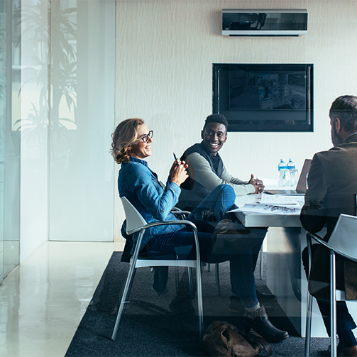 A group of people sitting at a table in a bright modern office