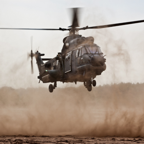 A military helicopter flying through the sky