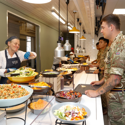 Military men being served by a cook in a cafeteria