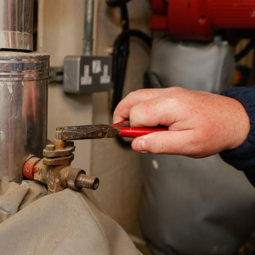 A hand of a person holding a wrench, ready to fix or repair something