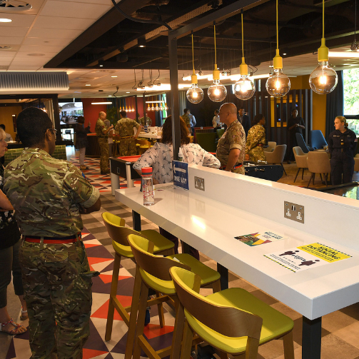 A diverse group of individuals gathered around a counter, engaged in conversation and interaction