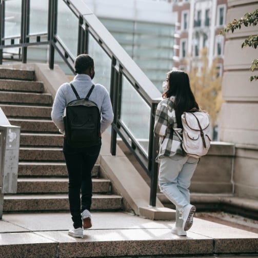 Two students walking down stairs in a school building