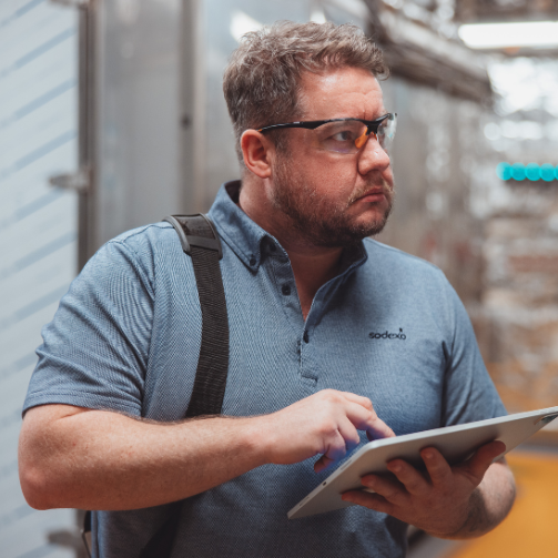 Sodexo employee checking maintenance with a digital tablet