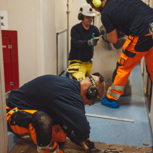 Three men working on floor refurbishment