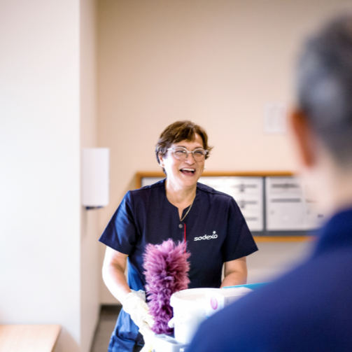 A Sodexo employee smiling at a client