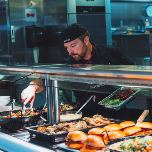 A Sodexo chef displaying a food counter