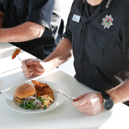 A uniformed man eating at a table