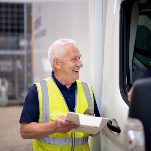 Happy logistics manager sharing information with van driver