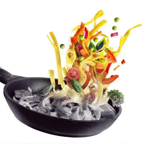A pan with food being tossed into it, creating a sizzling and appetizing scene of cooking