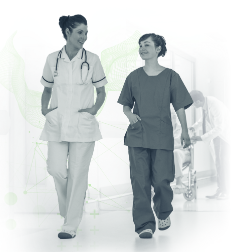 Two nurses in scrubs walking down a hospital hallway
