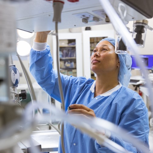A nurse is looking up, interacting with medical equipment