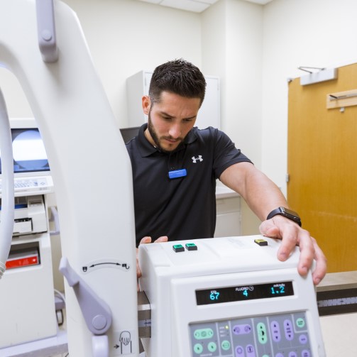 A man is fixing a clinical technology device