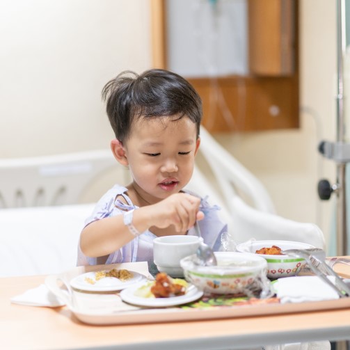 A child in his hospital bed is eating