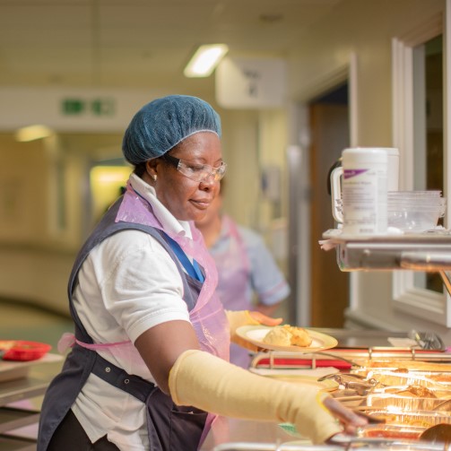 A hospital staff member is serving food