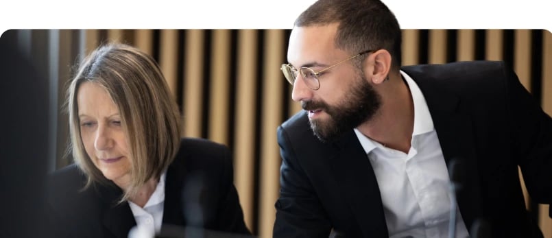 Two professionals collaborating at a desk in a modern office.