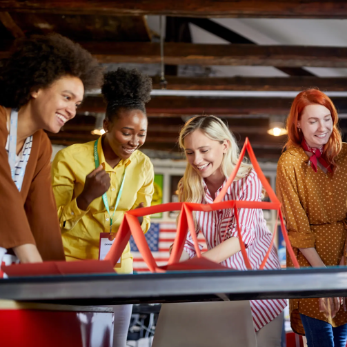 A diverse group of women collaborating on a project in a modern office setting