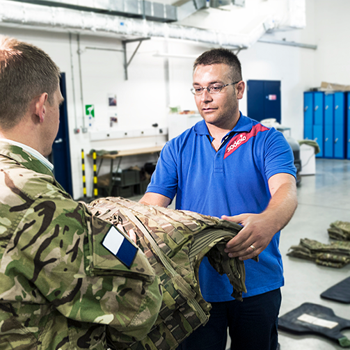 A man in the laundry delivering clothes to a military man