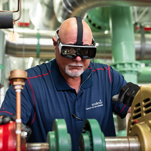 A man wearing a VR headset in a factory
