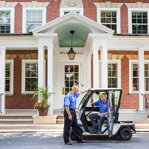 Two men riding in a golf cart