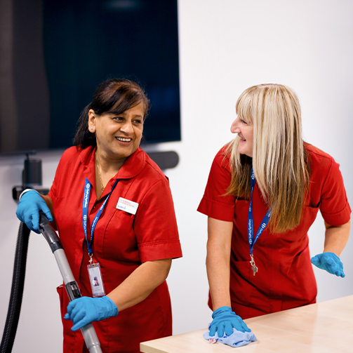Two women wearing red shirts standing side by side