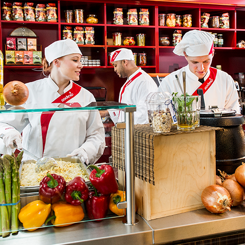 A diverse group of people cooking together in a modern kitchen