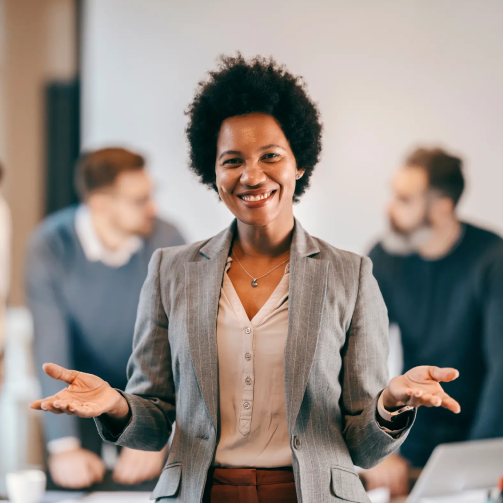 A businesswoman in a suit presenting to a group of people in a meeting