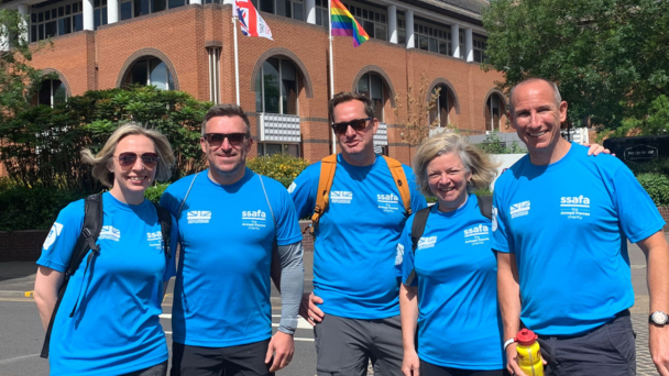 A group of people in blue shirts standing in front of a building