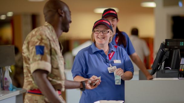 A soldier and a woman in uniform smiling, representing camaraderie and positivity