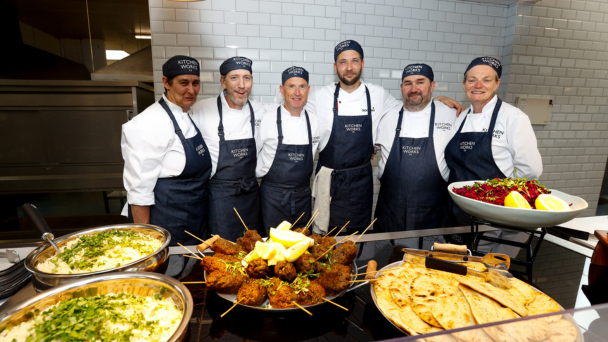 A group group of cooks standing in front of a buffet table