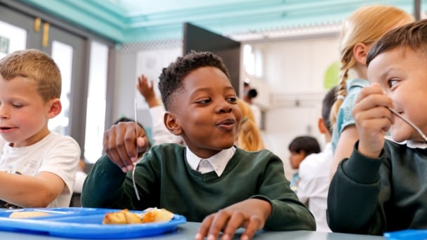 Group of kids enjoying lunch in school cafeteria