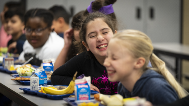 Group of kids enjoying lunch together in school cafeteria