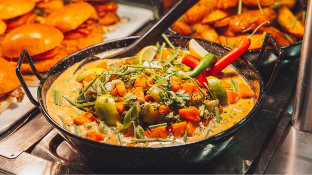 A bowl of food with a colorful mix of fresh vegetables and savory meat