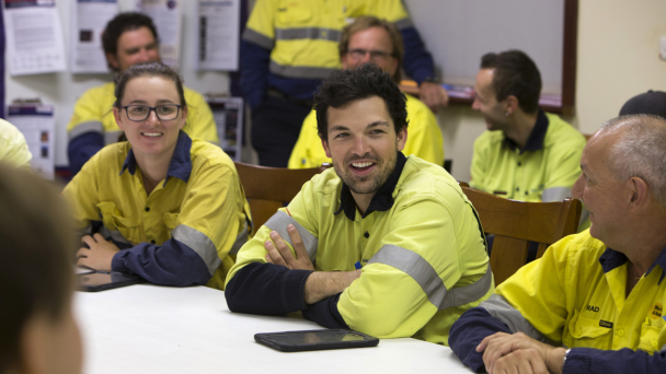 Group of individuals wearing work clothes seated at a table