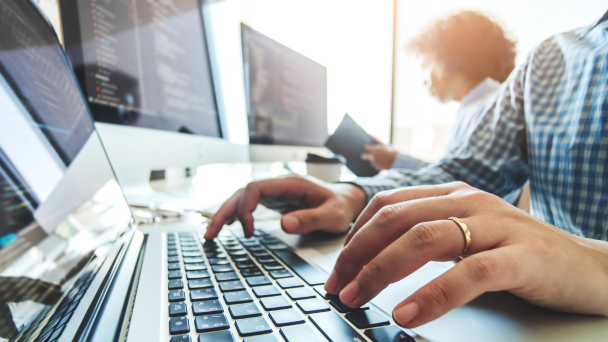Hands of a person typing on a laptop computer
