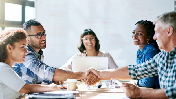 A diverse group of professionals shaking hands at a business meeting