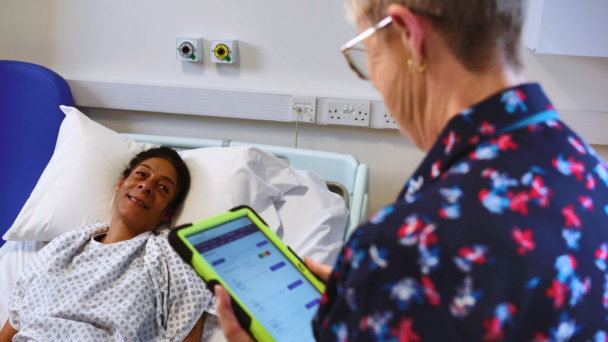Hospital employee gathering patient information on a tablet