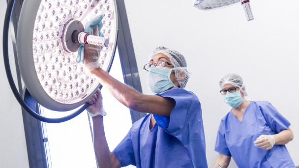 Two cleaners are cleaning an operation room and medical equipment