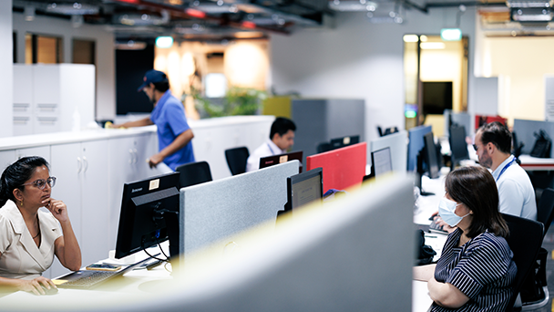 A diverse group of professionals working at desks in a modern office setting