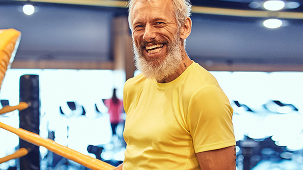 A bearded man happily holds a pole, radiating a warm smile