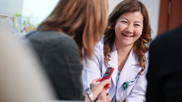 A woman conversing with another woman in an office