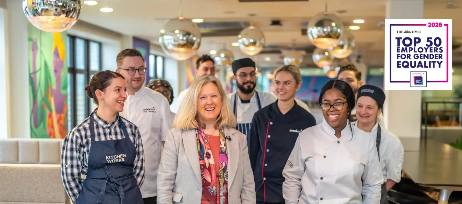 A group of Sodexo colleagues in professional and chef uniforms walking together in a modern workplace, with a “Top 50 Employers for Gender Equality 2026” badge displayed.