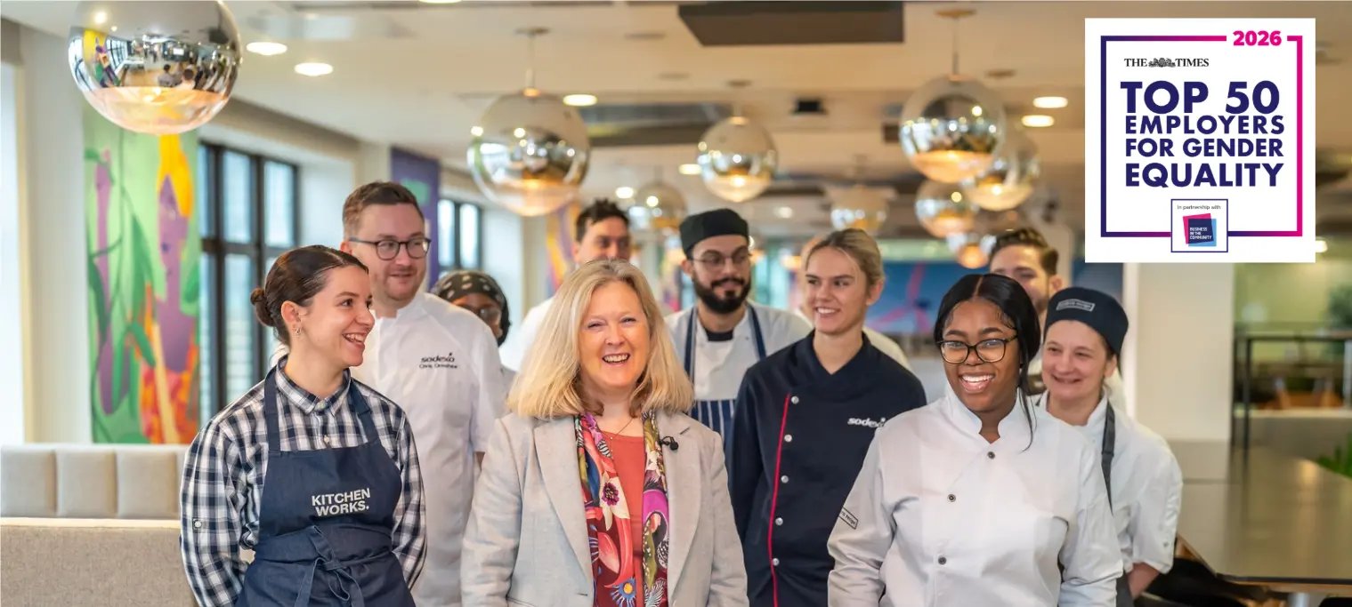 A group of Sodexo colleagues in professional and chef uniforms walking together in a modern workplace, with a “Top 50 Employers for Gender Equality 2026” badge displayed.
