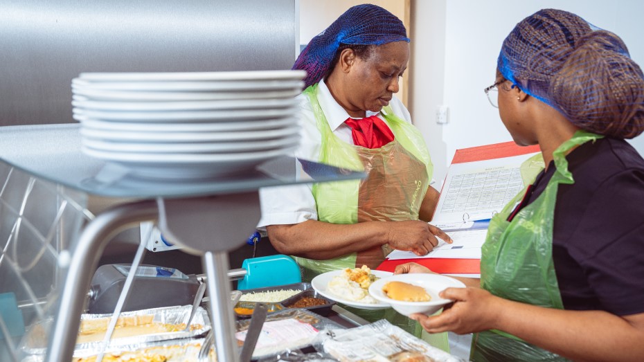 National Standards Image - woman serving food with manager following compliance checklist